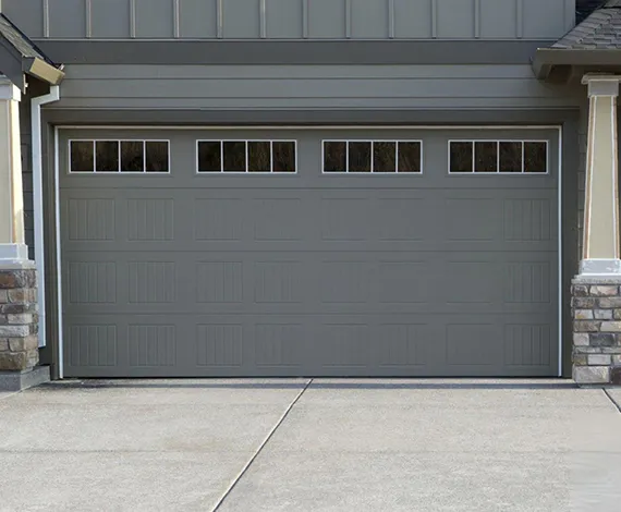 Dark grey modern garage door on a residential home with a clean concrete driveway.