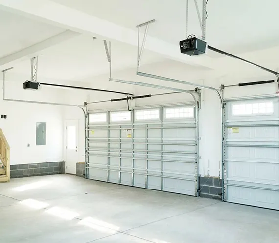 Interior view of a modern garage with multiple doors and a ceiling-mounted garage door opener.
