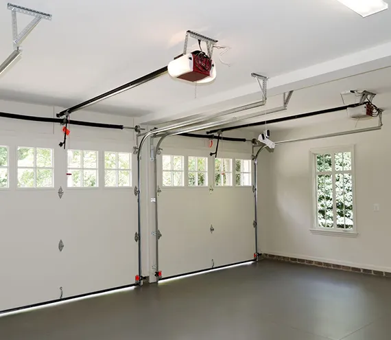 A spacious garage with a clean floor and a newly installed overhead garage door opener.