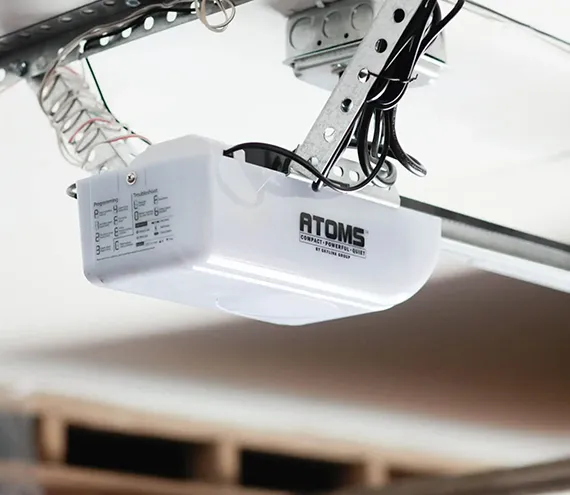 A close-up of a garage door opener mechanism attached to the ceiling.