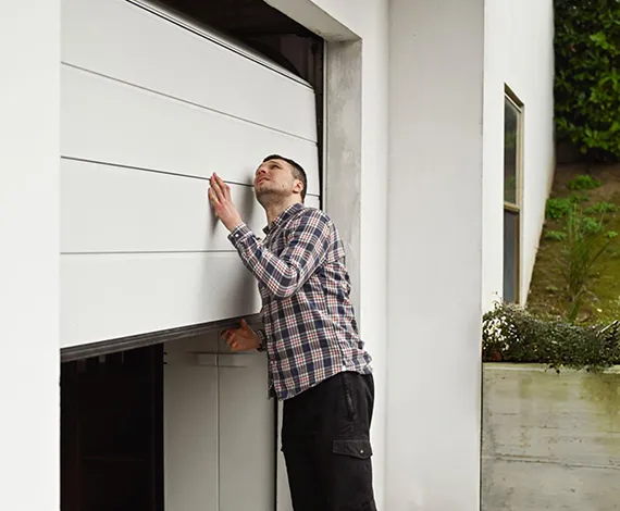 A technician inspecting a garage door, ensuring proper alignment and functionality.
